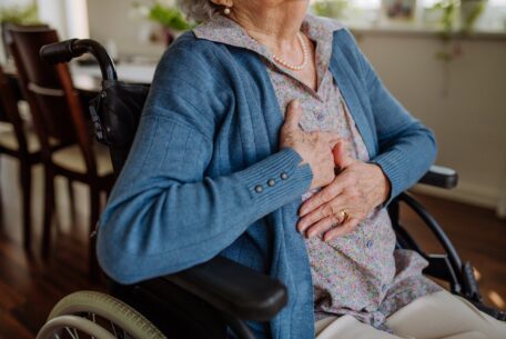 Close up of senior woman on wheelchair with pain in her chest.