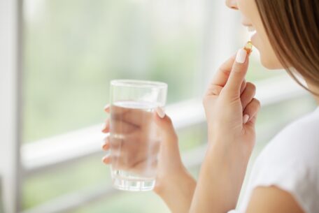 Beautiful Smiling Woman Taking Vitamin Pill, Dietary Supplement